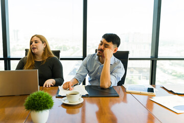 Bored businessman falling asleep during a business meeting