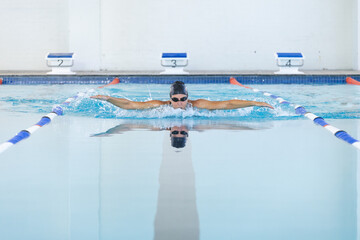 Caucasian female athlete swimmer swimming in a pool at a sports center