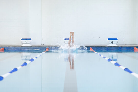 A swimmer dives into a pool at a competitive swimming event