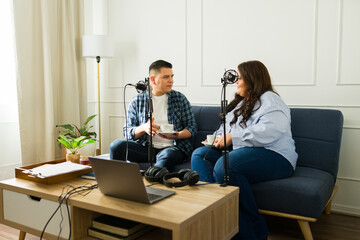 Hispanic podcast co-hosts enjoying recording an episode drinking coffee