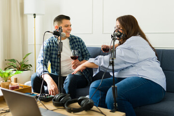 Cheerful podcast hosts smiling while recording a fun talk show