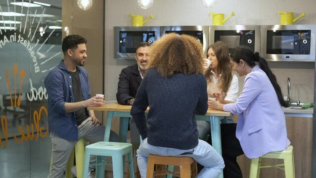 Multiethnic colleagues talking during break at work