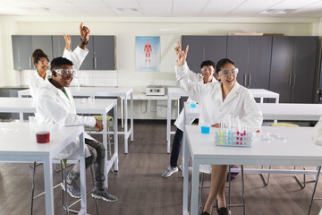 Diverse students celebrate in a science lab, with copy space