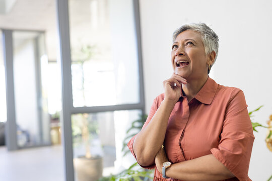 Senior biracial woman looks thoughtful in a home setting with copy space - Powered by Adobe