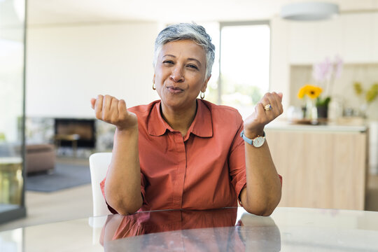 Senior biracial woman makes a playful gesture at home