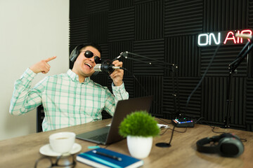 Attractive man having fun recording a radio show or podcast