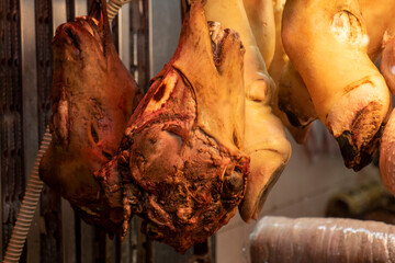 Sheep and cow heads, prepared to make trotters in a glass cabinet at the butcher shop