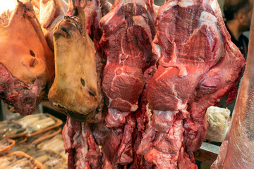 Sheep and cow heads, prepared to make trotters in a glass cabinet at the butcher shop