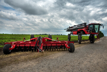 Fototapeta premium a new harrow cultivator, a self-propelled sprayer stands near a field of green beets, of agricultural technologies