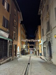 Fototapeta na wymiar Medieval cobbled street shops buildings at night