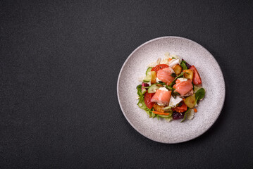 Delicious juicy salad with salmon, tomatoes, cucumber, herbs, pumpkin seeds