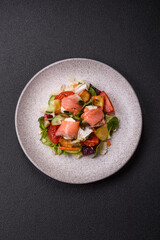 Delicious juicy salad with salmon, tomatoes, cucumber, herbs, pumpkin seeds