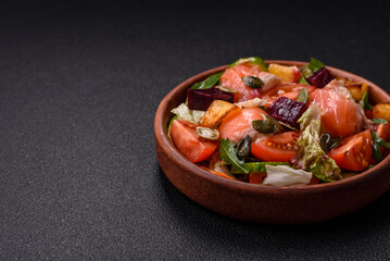 Delicious juicy salad with salmon, tomatoes, cucumber, herbs, pumpkin seeds