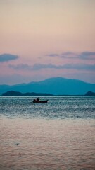 Rybak na łodzi Tajlandia Koh Chang wyspa, łowienie ryb na oceanie z widokiem na góry o zachodzie...