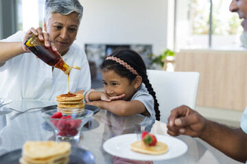 Biracial woman serves breakfast of pancakes at home