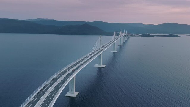 Aerial view of majestic long bridge crossing the Mediterranean sea. Cars crossing the blue sea on the bridge.