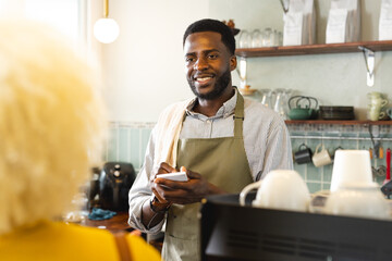 African American barista serves coffee at a cozy cafe