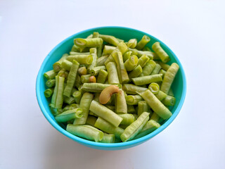 raw long beans in bowl on white background