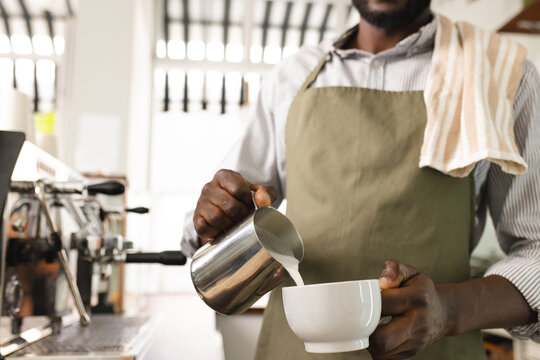 African American barista prepares coffee in a cafe, with copy space
