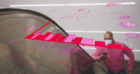 Covid-19 data processing against african american senior man wearing face mask using smartphone