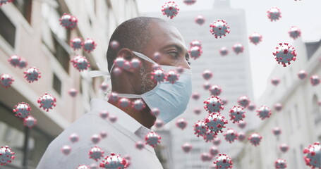 Image of covid 19 cells over african american man wearing face mask