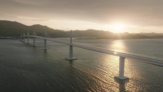 Majestic modern bridge crossing the blue sea at golden sunset. Long bridge connecting Mediterranean islands.