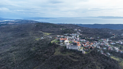 Fototapeta premium Aerial view of the charming village of Grobnik near Rijeka, Croatia, showcasing an old fortress atop a hill and a quaint church