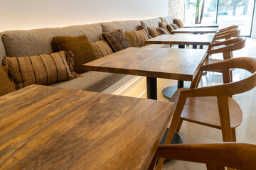 Wide shot of some empty wooden tables in the restaurant of a rustic hotel. Tourism concept