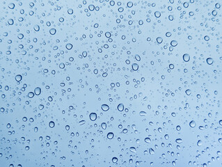 Drops of rain on glass with blue background