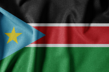 Fototapeta premium National Flag on Textured Fabric Background. Silk textured flag, realistic wave and flag look. SS Flag of South Sudan