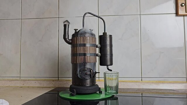 The process of distilling wine at a mini distillery using wood. Volume 400 ml.
