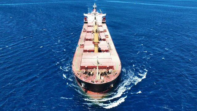 Aerial drone video of huge industrial bulk carrier tanker cruising in deep blue Aegean sea