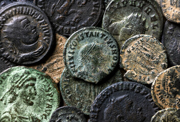Ancient Roman coins with emperors portraits close-up, pile of old metal money, top view of vintage...