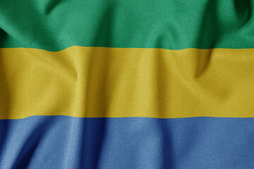 National Flag on Textured Fabric Background. Silk textured flag, realistic wave and flag look. GA  Flag of Gabon