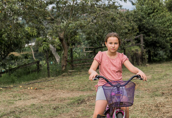 Fototapeta na wymiar niña al aire libre montando bicicleta en el campo 
