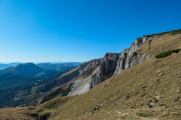 Fototapeta premium Panoramic view from top of mountain peak Hohe Veitsch in Mürzsteg Alps, Styria, Austria. Idyllic hiking trail in alpine terrain. Wanderlust remote Austrian Alps in autumn. Steep cliff rock formation