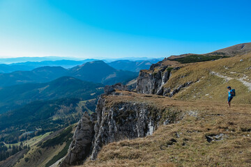 Hiker Woman on edge of steep cliff on top of mountain peak Hohe Veitsch, Mürzsteg Alps, Styria,...