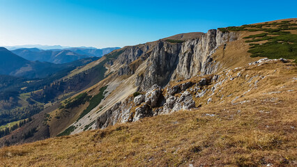 Panoramic view from top of mountain peak Hohe Veitsch in Mürzsteg Alps, Styria, Austria. Idyllic hiking trail in alpine terrain. Wanderlust remote Austrian Alps in autumn. Steep cliff rock formation