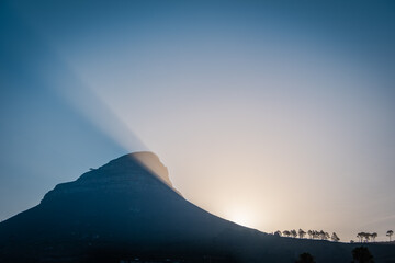 Last sun rays behind Signal Hill in Cape Town, South Africa