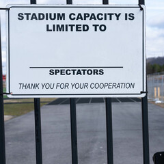 Fototapeta premium Black and white, stadium capacity limit sign hanging on a gate.