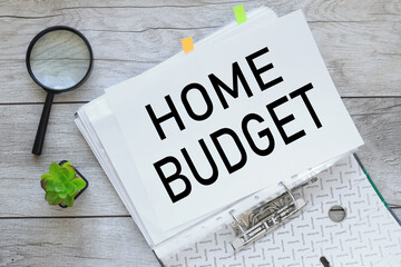 HOME BUDGET text on white paper on a folder with documents