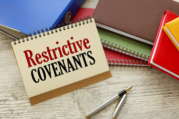Restrictive Covenants text on the page. notepad on blue folder