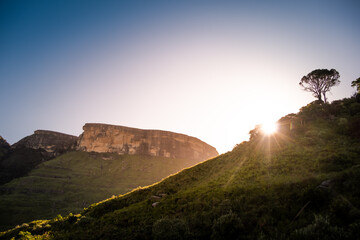 Sun setting behind a hill in Royal Natal park in Drakensberg, South Africa