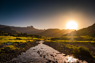 Sun setting over a river in Royal Natal park in Drakensberg, South Africa