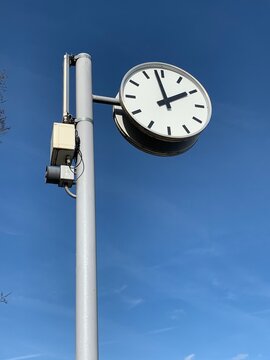 Uhr  / Bahnhofsuhr vor blauem Himmel / Hintergrund im Hochformat am Bahnhof

