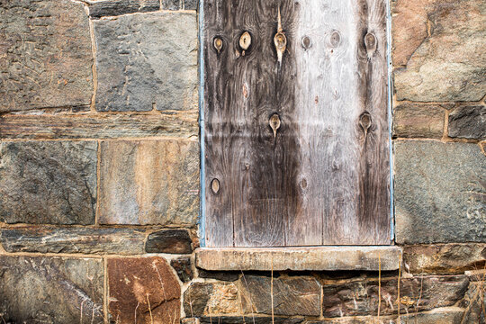 Weathered red wood siding with posted, no trespassing sign