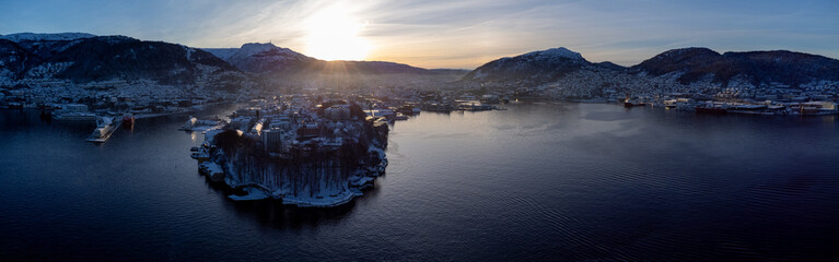 Early morning winter drone aerial panorama of Bergen city in Norway. Sun rising up behind a city...