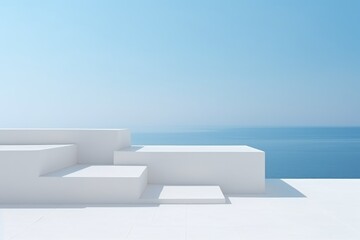 White minimalist geometric structures against a calm blue sea and clear sky backdrop. Minimalist Geometric Architecture Overlooking Sea