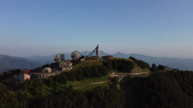 Aerial view of the big parabolic antenna of the radio station abandoned on the top of Monte Giogo, used during cold war. Comano, Massa and Carrara province, Lagastrello lake, Tuscany, Italy. 