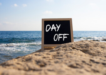 Day off symbol. Day off black chalk blackboard. Beautiful sea background. Business and Day off concept. Copy space.